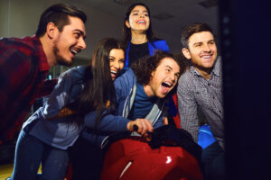 A,Group,Of,Friends,Playing,Arcade,Machine.
